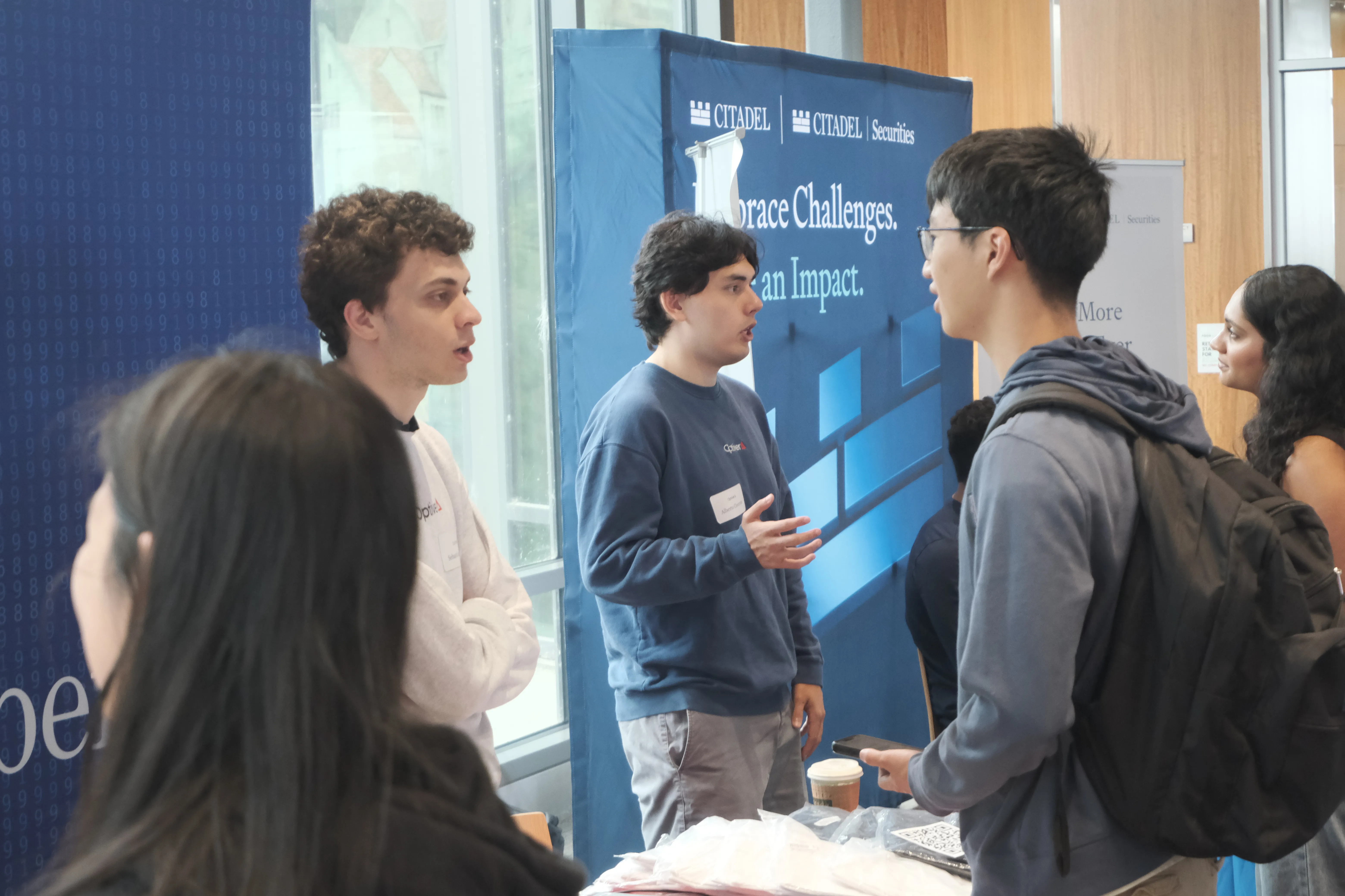 Students talking to sponsor representatives at the Quant Finance Career Fair